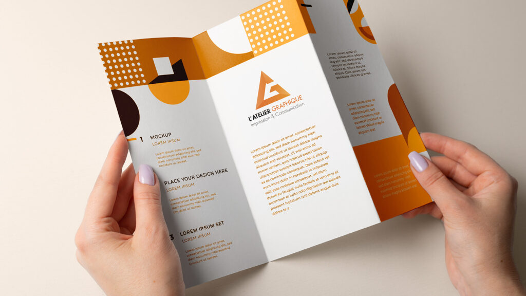 Impression de dépliant 3 volets publicitaire avec finitions professionnelles et design géométrique orange et blanc, tenu en main pour la communication de marque