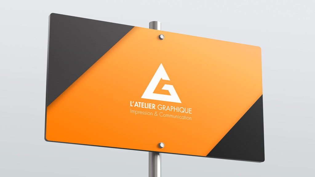 Panneau de signalétique extérieur rectangulaire orange et noir affichant le logo blanc de L'Atelier Graphique sur un poteau métallique